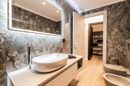 a bathroom with a sink and two toilets at ReMia Suites & Leisure in Alassio