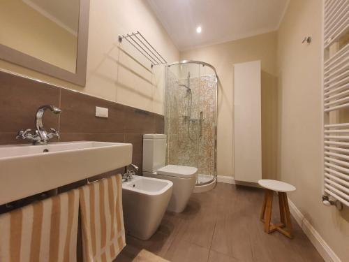 a bathroom with a sink and a toilet and a shower at Hotel De La Plage in Pietra Ligure