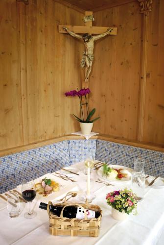 a table with a cross on the wall and a crucifixurrection at Alpenhotel Tirol in Galtür