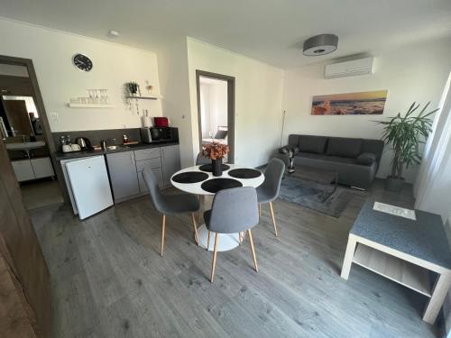 a kitchen and a living room with a table and chairs at Sophia Apartman Gödöllő in Gödöllő