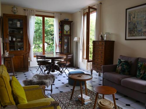 a living room with a couch and a table at Charmante villa aux portes de Paris in Issy-les-Moulineaux