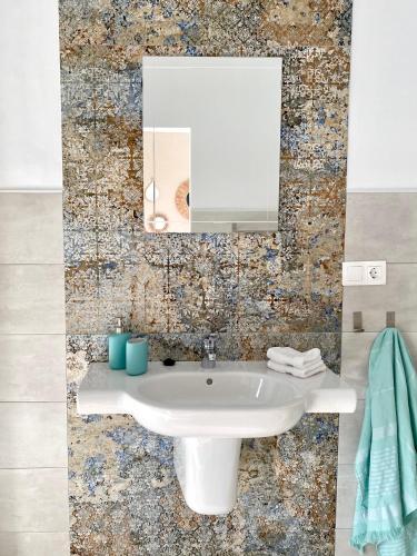 a bathroom with a white sink and a mirror at Casa de Los Lirios in Muro de Alcoy