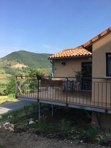 a balcony of a house with a table and chairs at Gîte La Liaucoussette in Mostuéjouls
