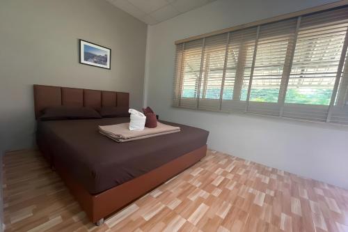 a bedroom with a large bed and a wooden floor at Davy Cottage Phuket in Ban Riang