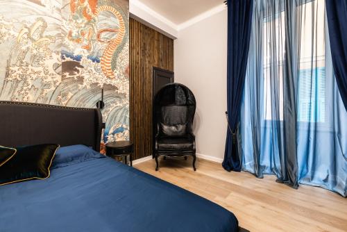 a bedroom with a bed and a chair at ReMia Suites & Leisure in Alassio