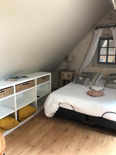 - une chambre avec un lit doté d'étagères blanches et une fenêtre dans l'établissement Le clos de la Pommeraie maisonnette, à Carly