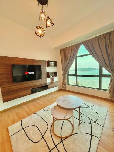 a living room with a table and a tv at imperium residence kuantan in Kuantan