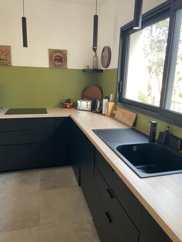 - une cuisine avec un évier et un comptoir avec une fenêtre dans l'établissement Casa Sophie, à Capo