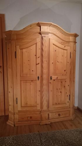 a wooden cabinet with two doors in a room at Antares am See in Maurach