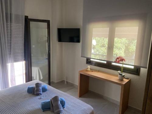 a bedroom with a bed and a desk and a window at FILIRA Luxurious Apartment - by Ploumis in Stavros