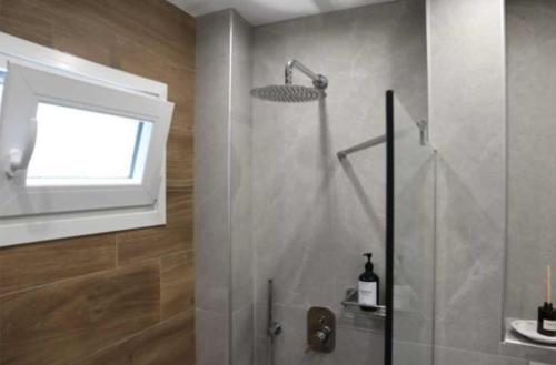a shower in a bathroom with a window at FILIRA Luxurious Apartment - by Ploumis in Stavros