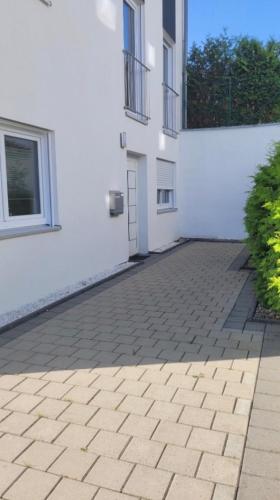 a white building with a brick patio in front of it at Fewo Huber in Bad Waldsee