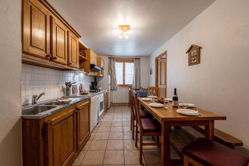 une cuisine avec une table, un évier et un comptoir dans l'établissement Chalet Le Choucas N°1, à Levassaix