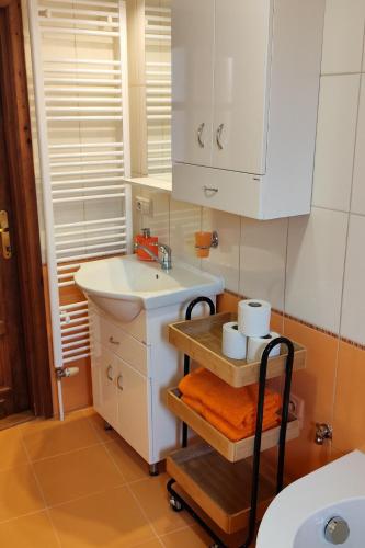a bathroom with a sink and white cabinets at Apartment My Way in Poprad