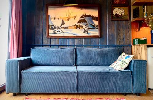 a blue couch in a living room with a painting at dla mnie się podoba in Krzywiec