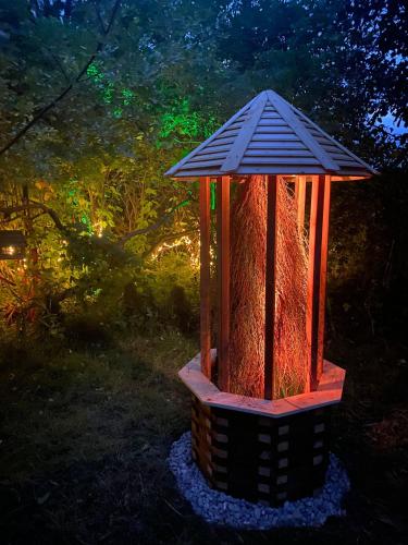 a lighted bird house in the middle of a yard at dla mnie się podoba in Krzywiec