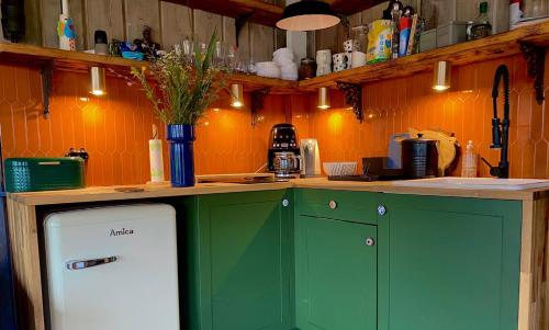 a kitchen with green cabinets and a white refrigerator at dla mnie się podoba in Krzywiec