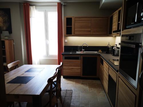une cuisine avec une table en bois et une table ainsi qu'une salle à manger dans l'établissement Appartement dans le centre ville Avignon, à Avignon