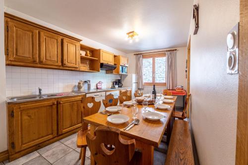 une cuisine avec une table en bois et des plaques de cuisson. dans l'établissement Chalet Le Choucas n°2, à Levassaix