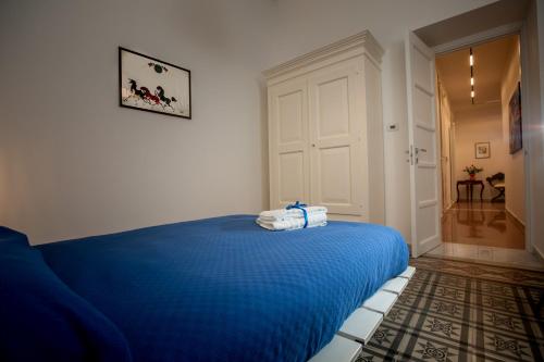 a bedroom with a blue bed with towels on it at Abate Luxury Interno 3 in Bari