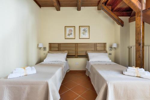 Dos camas en una habitación con sábanas blancas. en La Loggia House by BarbarHouse, en Manduria