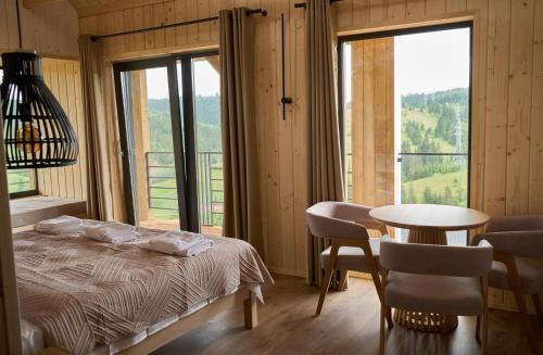 a bedroom with a bed and a table with chairs at Шале Green Land in Bukovel