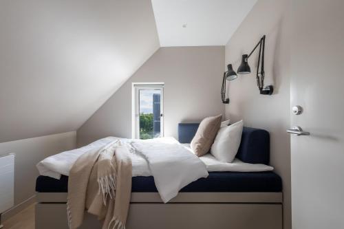 a bedroom with a bed with a blue bench at Unity Malmö - A Studio Hotel in Malmö