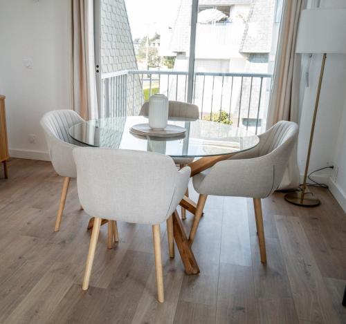 une salle à manger avec une table et des chaises en verre dans l'établissement Appartement pied dans l'eau - La Comtesse, à Saint-Quay-Portrieux