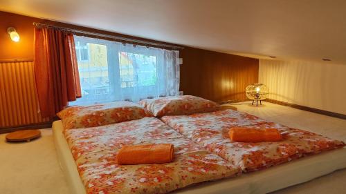 a bedroom with a large bed with orange pillows at Apartment My Way in Poprad