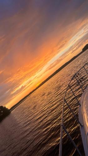 a boat on a body of water at sunset at Yachthouse in Plateliai