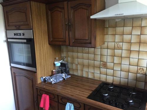 une cuisine avec des armoires en bois et un four à plaques de cuisson dans l'établissement Blue escape, à Saint-Brieuc