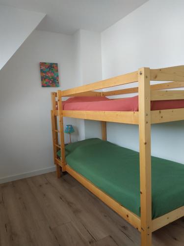 Ce lit superposé se trouve dans une chambre située à côté d'un mur. dans l'établissement Appartement vue mer, à Carnac