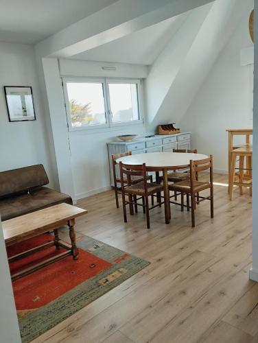 une salle à manger avec une table et quelques chaises dans l'établissement Appartement vue mer, à Carnac