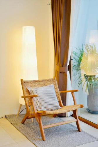 a wicker chair sitting in a room with a window at SaroRach pool villa resort Kohlarn in Ko Larn