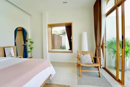 a bedroom with a bed and a chair and a surfboard at SaroRach pool villa resort Kohlarn in Ko Larn