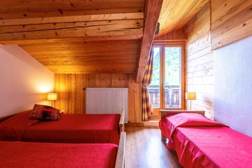 zwei Betten in einem Zimmer mit Holzwänden in der Unterkunft Chalet Le Choucas N°3 in Levassaix