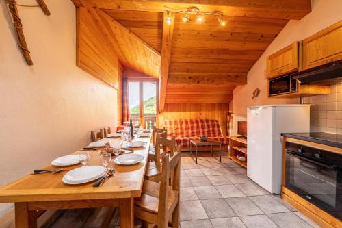 une salle à manger avec une grande table et un réfrigérateur dans l'établissement Chalet Le Choucas N°3, à Levassaix