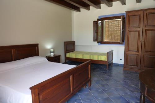 a bedroom with a bed and a bench and a window at Case Vacanze Casa Romana in Lascari