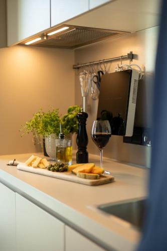 a plate of cheese and a glass of wine on a counter at Unity Malmö - A Studio Hotel in Malmö