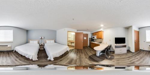 a hotel room with two beds and a desk at Birch Hill Suites Dayton-WP AFB in Beavercreek