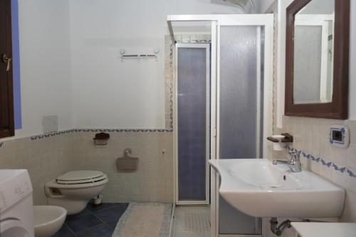 a bathroom with a toilet and a sink and a shower at Case Vacanze Casa Romana in Lascari