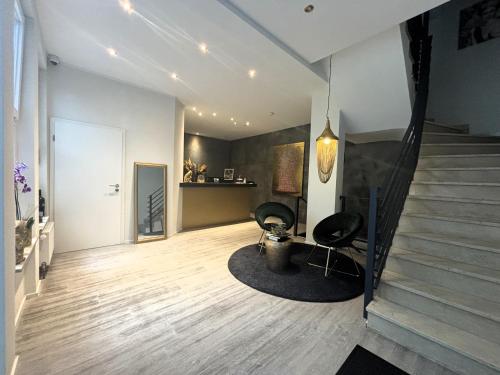 ein Wohnzimmer mit 2 Stühlen und einer Treppe in der Unterkunft Boutique Hotel Q8 By Simplex in Germersheim