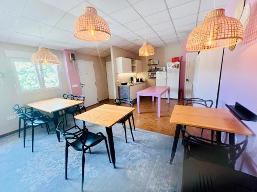 a room with tables and chairs and a kitchen at Casa de Los Lirios in Muro de Alcoy