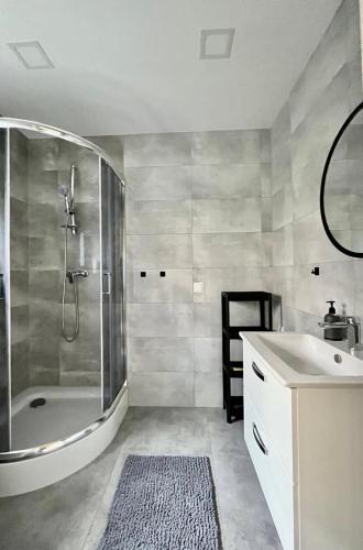a bathroom with a shower and a sink at Nowe Domki Letniskowe in Pobierowo