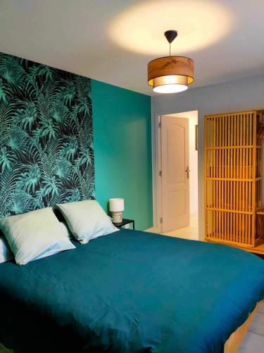 - une chambre avec un grand lit bleu et un mur bleu dans l'établissement Gîte 6 P au cœur des vignobles, à Lazenay