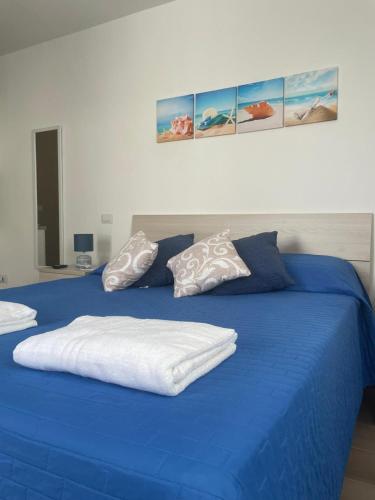 a blue bed with blue sheets and pillows on it at HOUSE Apartment in Torre Squillace