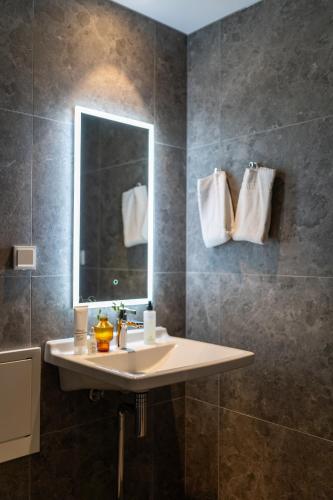 a bathroom with a sink and a mirror at Unity Malmö - A Studio Hotel in Malmö
