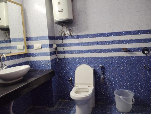 a bathroom with a toilet and a sink at New Gulmarg Manali in Manāli