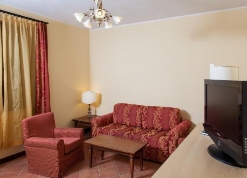 a living room with a couch and a chair and a tv at Villa Borri in Casciana Terme