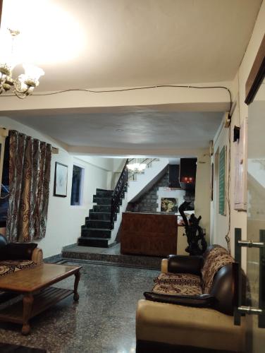 a living room with two couches and a staircase at New Gulmarg Manali in Manāli